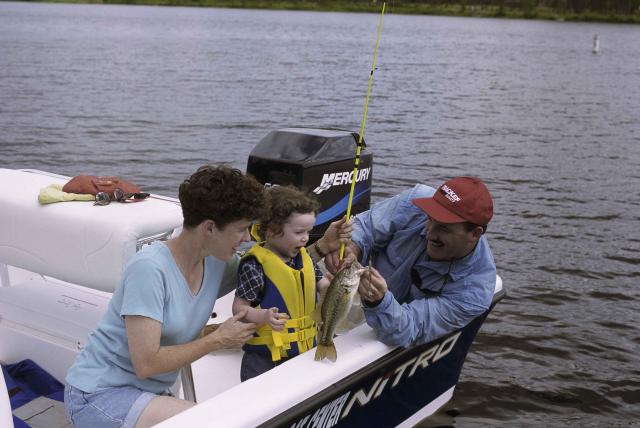 Family recreational boating and fishing on lake